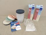 three cups, a container, and a bag of toilet paper on a table