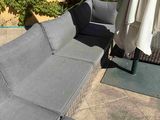 a couch that is sitting on a patio with an umbrella