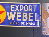 une affiche accrochée au mur sur laquelle on peut lire « export weber bière de mars »