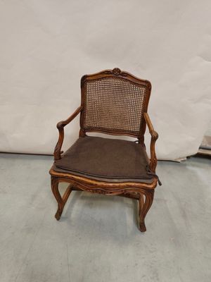 une image représentant une chaise en bois dont l'assise est recouverte d'un tissu marron