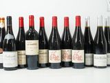 plusieurs bouteilles de vin sont alignées sur une surface blanche
