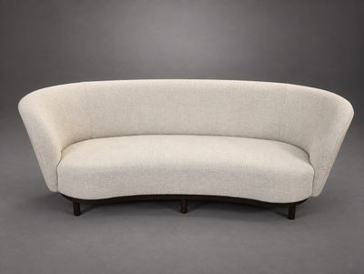 a white curved sofa against a gray background