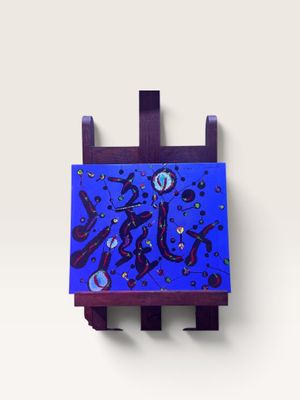 tableau violet et bleu posé sur un chevalet en bois contre un mur blanc