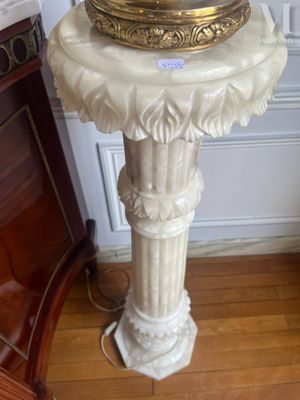 un socle en marbre blanc surmonté d'une horloge