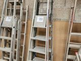 de nombreuses échelles empilées contre un mur
