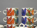 four cups and a teapot sitting on a table