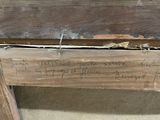 a piece of wood with writing on it sitting on the floor