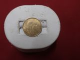 une pièce d'or posée sur un objet blanc