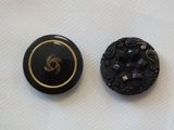 pair of black and gold buttons on a white surface