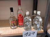 Plusieurs bouteilles d'alcool sont posées sur une étagère dans un magasin