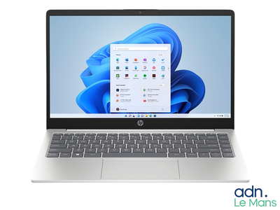 the laptop is open on a white surface with a blue background