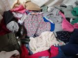 a pile of clothes that is on a bed