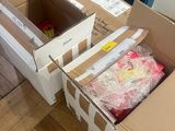 two boxes of clothes sitting on the floor next to each other
