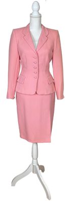 a pink suit and skirt on a mannequin stand