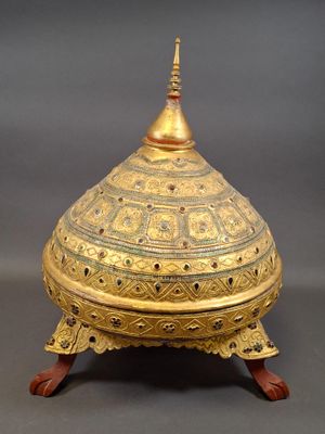 an ornate gold plated box with a domed top on a wooden stand