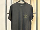 un t-shirt noir suspendu à un porte-vêtements en métal dans une pièce