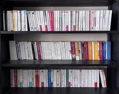 une étagère contenant de nombreux livres dans une pièce
