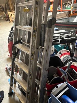 a ladder that is next to a pile of assorted items