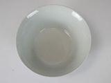 a white bowl on a white table with a white background