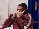 a man sitting in a chair talking on a cell phone