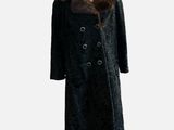 black coat with fur collar on mannequin stand against white background