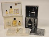 deux boîtes de parfum et une boîte de parfum posées sur une surface blanche