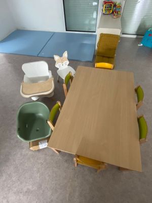 une table et des chaises en bois dans une pièce recouverte d'un tapis bleu