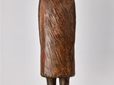 statue of a man in a hat and coat standing on a wooden base