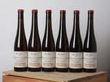 six bouteilles de vin sont posées sur une caisse en bois