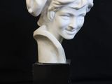 a white marble bust of a woman with a turban on her head
