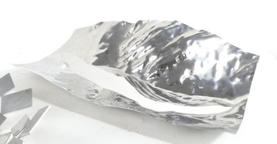 a piece of silver foil on a white surface