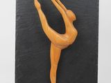 a close up of a figurine of a woman on a black plate