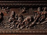 a wooden carving of a group of people on a boat