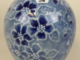 a blue vase with flowers on it on a table
