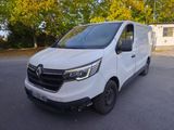 La camionnette blanche est garée sur le parking près des arbres.