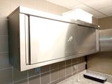 a stainless steel medicine cabinet in the corner of a bathroom