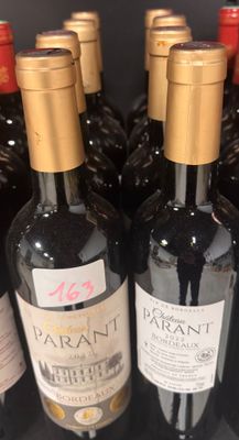 bottles of wine are lined up in a row on a shelf