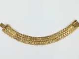 a close up of a gold bracelet on a white background