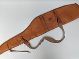 an old leather gun case hanging on a wall with a strap