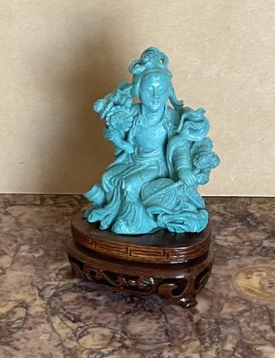 une petite statue représentant une femme assise sur une table