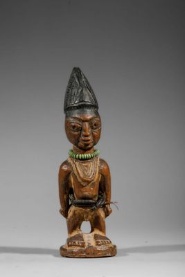 une figurine en bois représentant un homme coiffé d'un chapeau et portant un collier