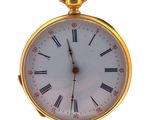 a gold pocket watch with roman numerals on the face
