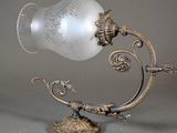 a glass lamp that is on a stand on a table