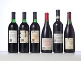 six bottles of wine are lined up on a table