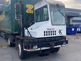 un camion vert et blanc garé sur un parking