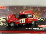 a red toy car in a display case on a table
