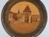 a wooden plate with a picture of a castle on it