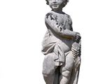 a small statue of a boy holding a stick