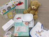 un ours en peluche posé à côté d'une boîte contenant des articles pour bébé
