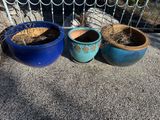 trois pots contenant des plantes, posés sur un banc